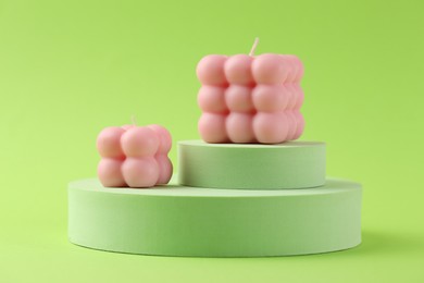 Photo of Beautiful pink bubble candles and podiums on green background