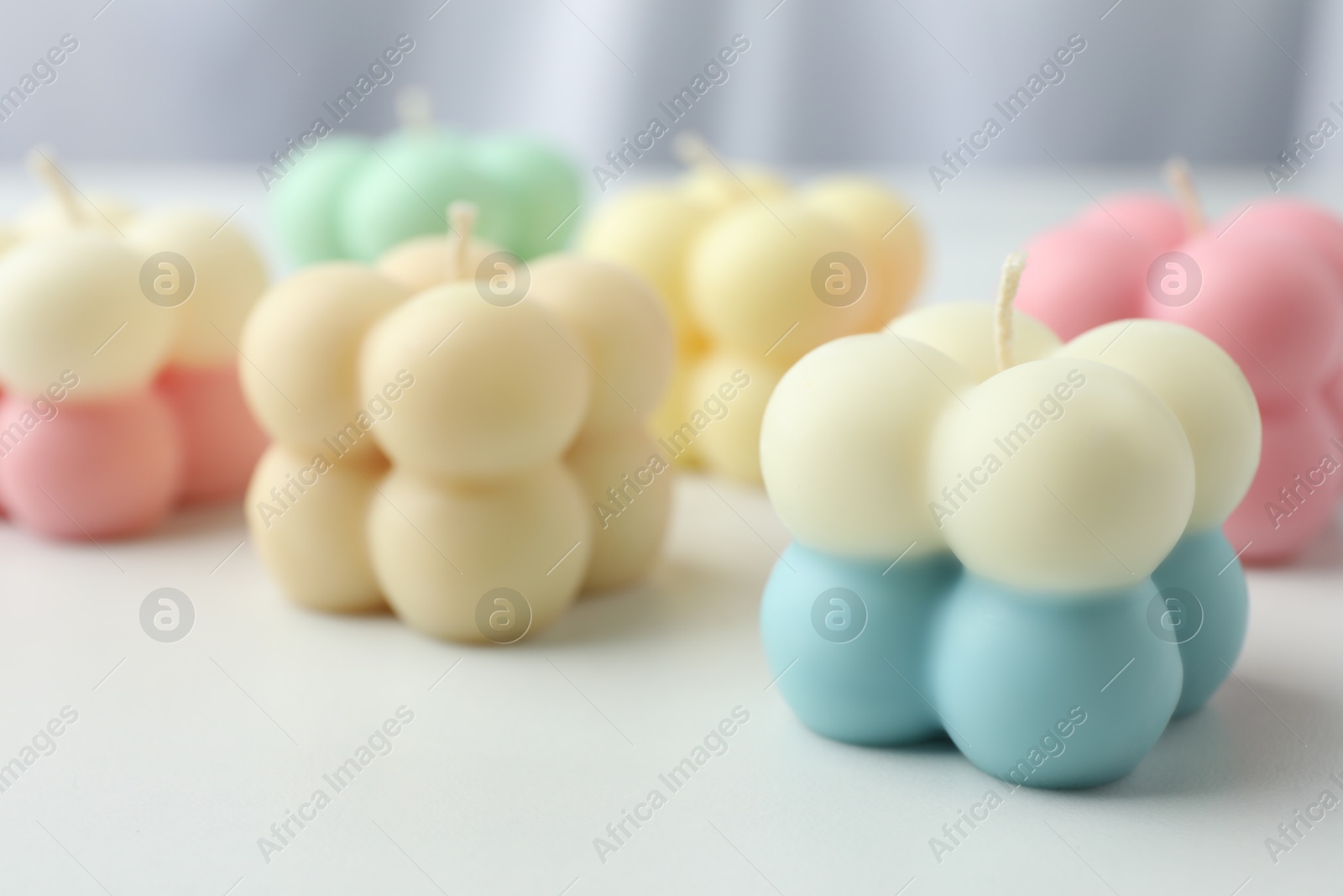 Photo of Different stylish bubble candles on white table, closeup