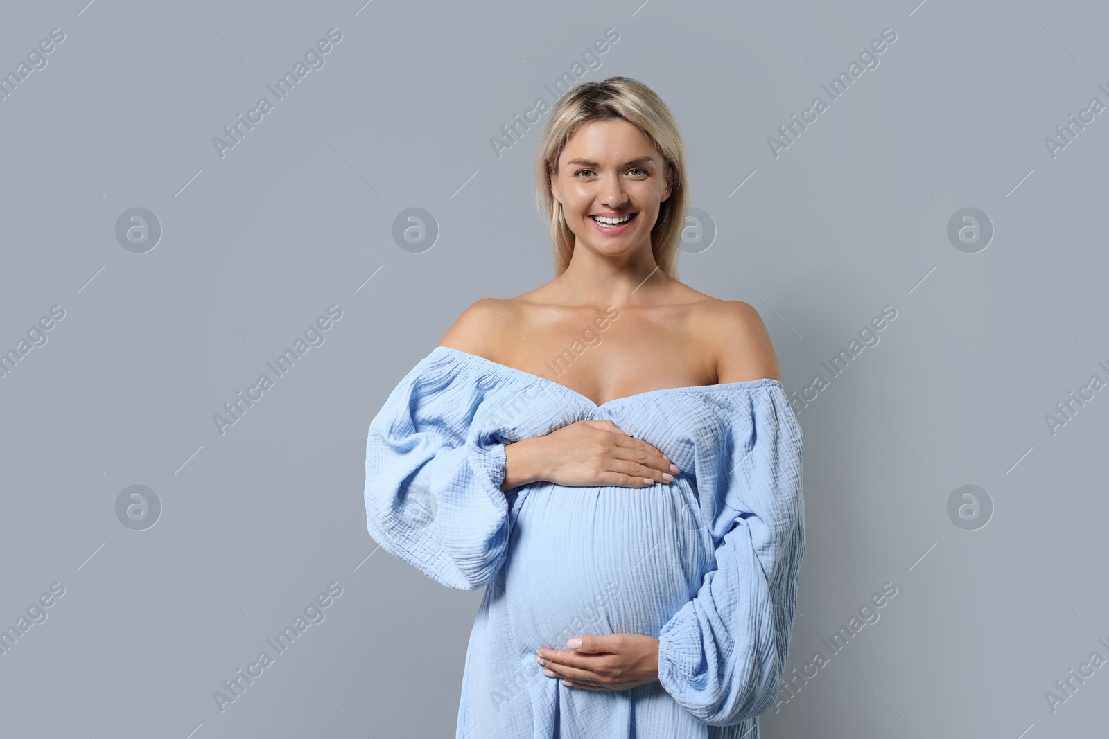 Photo of Portrait of beautiful pregnant woman on grey background