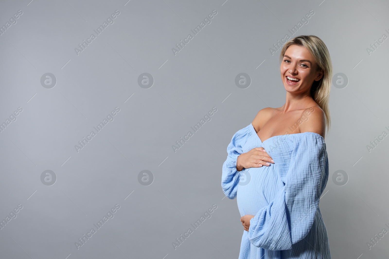 Photo of Portrait of beautiful pregnant woman on grey background, space for text