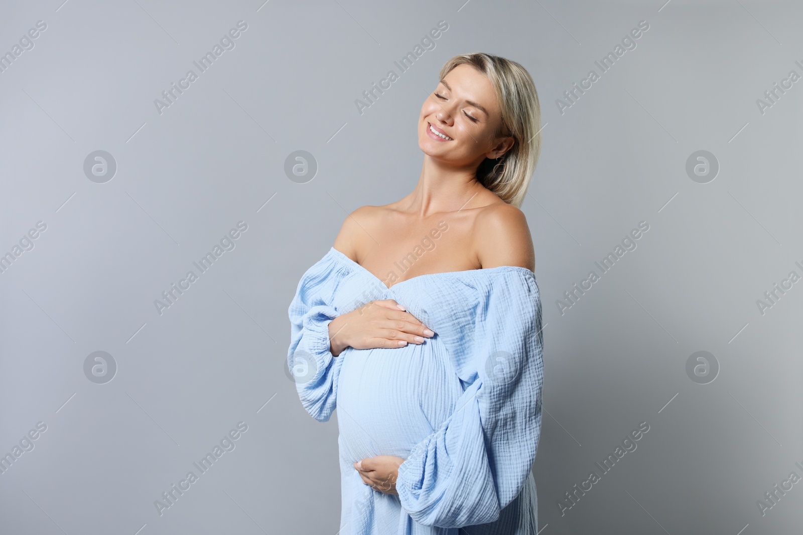 Photo of Portrait of beautiful pregnant woman on grey background