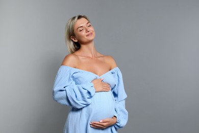 Photo of Portrait of beautiful pregnant woman on grey background