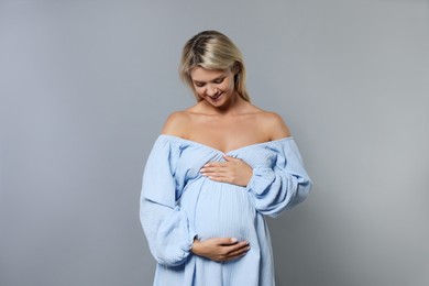 Photo of Portrait of beautiful pregnant woman on grey background