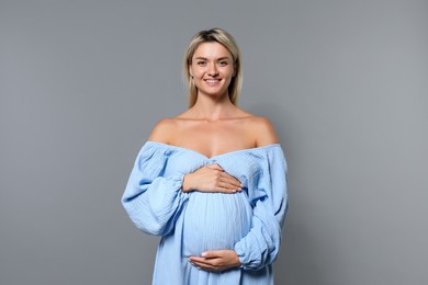 Photo of Portrait of beautiful pregnant woman on grey background