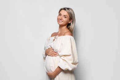 Photo of Portrait of beautiful pregnant woman on white background