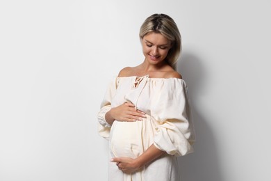 Photo of Portrait of beautiful pregnant woman on white background