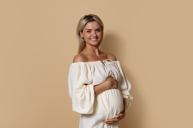 Portrait of beautiful pregnant woman on beige background