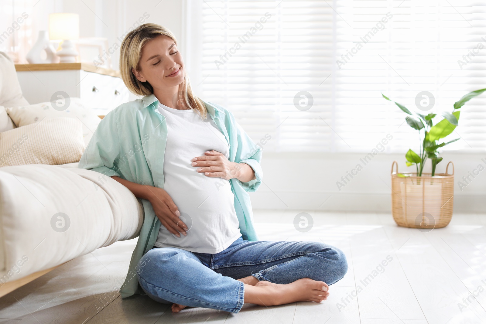 Photo of Portrait of beautiful pregnant woman on floor at home