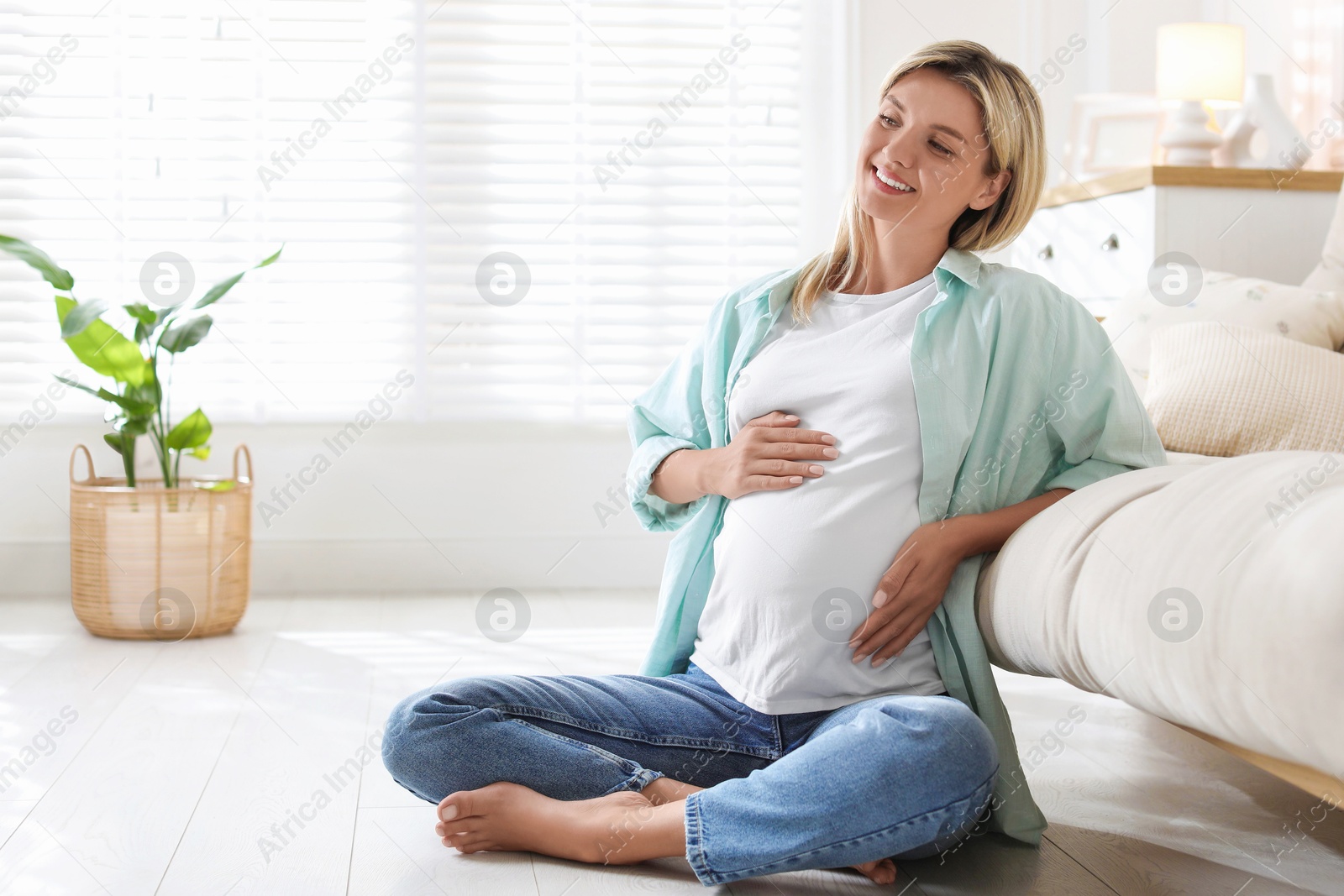 Photo of Portrait of beautiful pregnant woman on floor at home