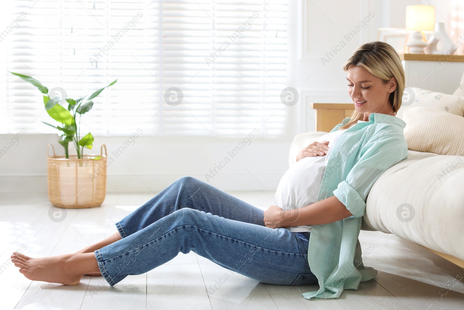 Photo of Portrait of beautiful pregnant woman on floor at home