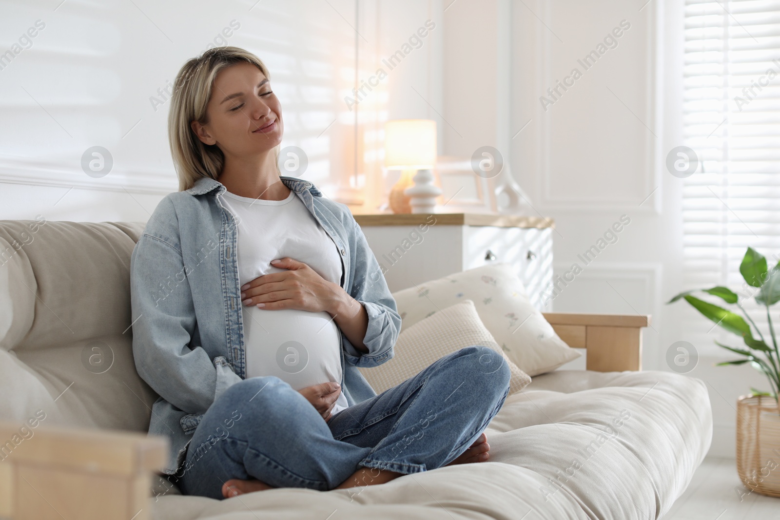 Photo of Portrait of beautiful pregnant woman on sofa at home