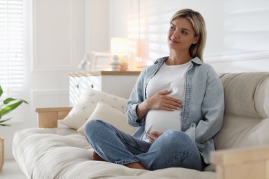 Photo of Portrait of beautiful pregnant woman on sofa at home