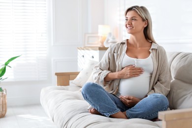 Photo of Portrait of beautiful pregnant woman on sofa at home