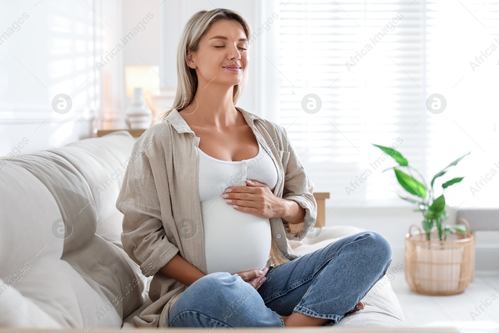 Photo of Portrait of beautiful pregnant woman on sofa at home