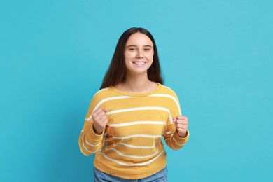 Photo of Happy young student on light blue background