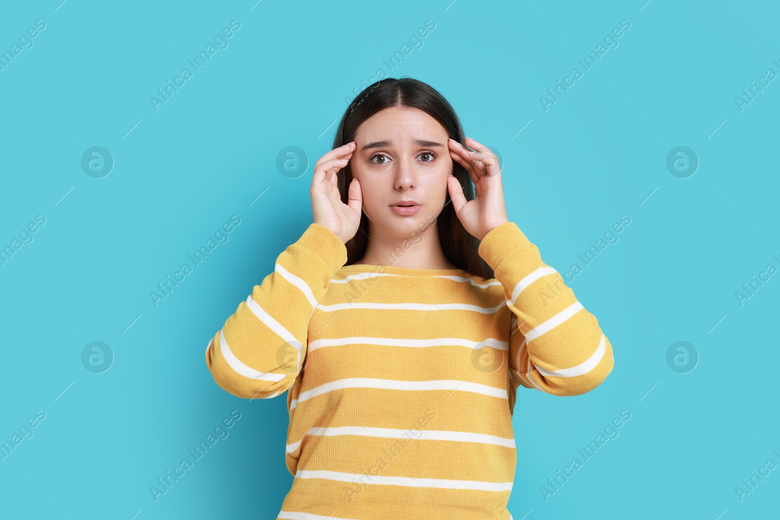 Photo of Stressful student before exam on light blue background