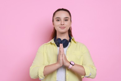 Photo of Young student praying for good exam result on pink background