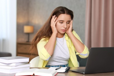 Photo of Young student having stress before exam at desk