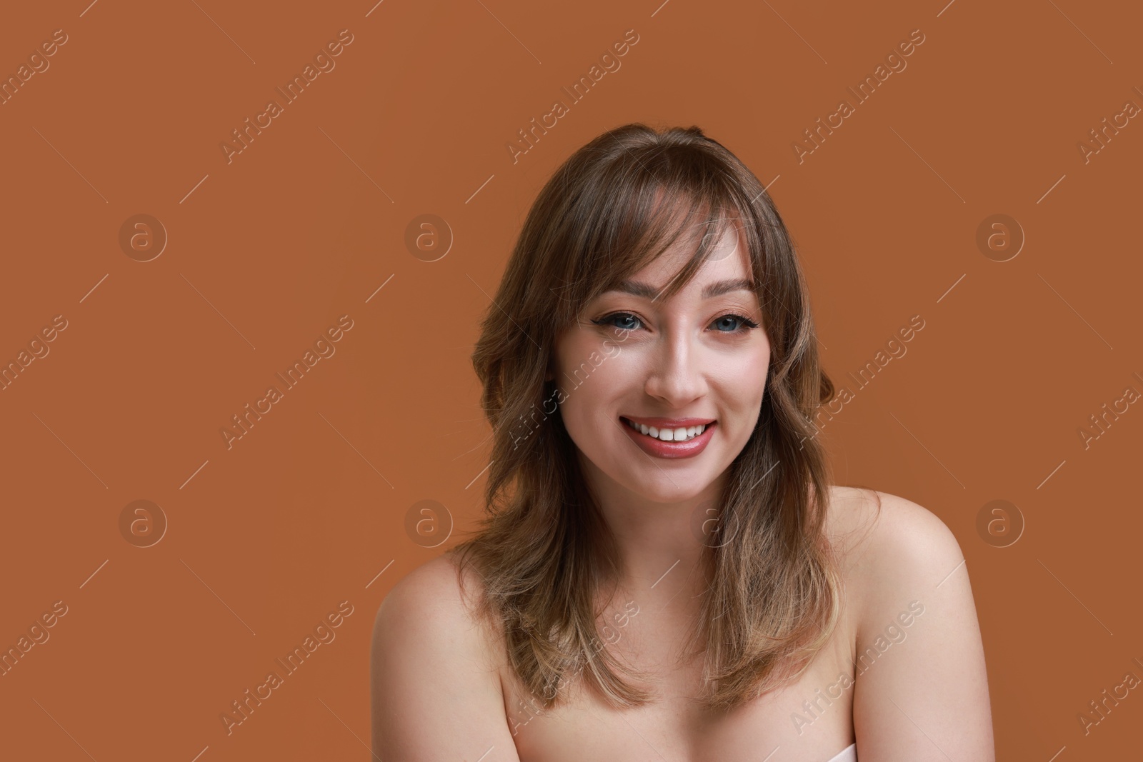 Photo of Attractive woman with stylish haircut on brown background, space for text