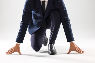 Photo of Businessman in starting position for run on white background, closeup