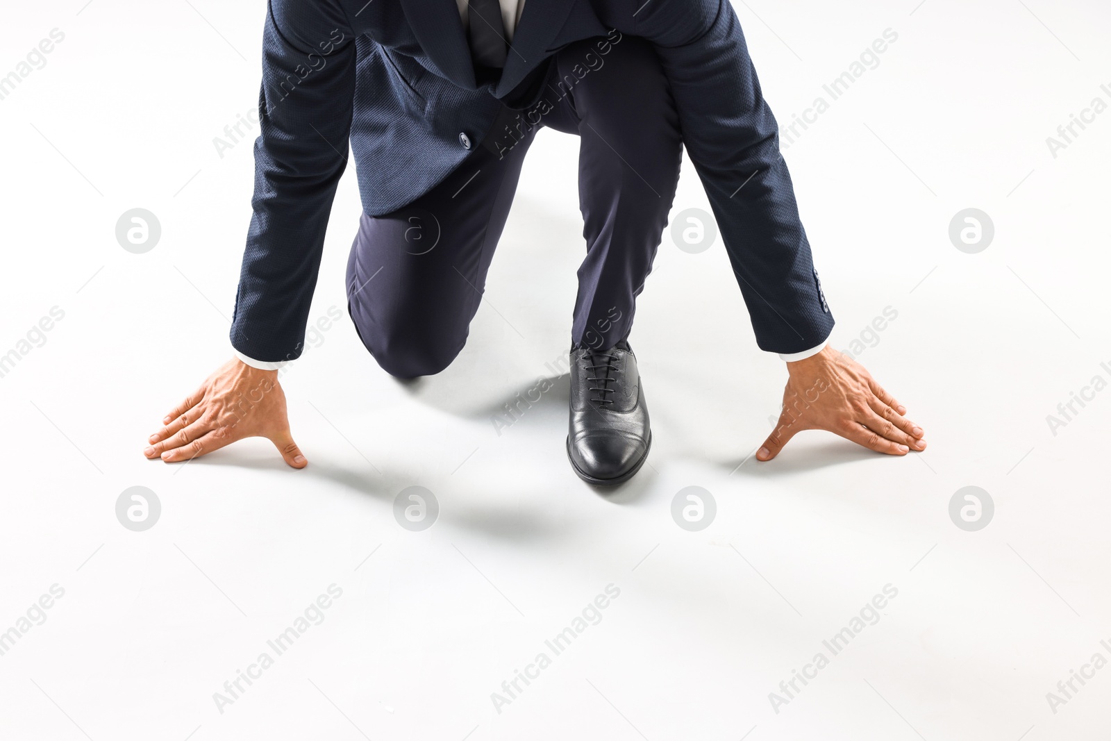 Photo of Businessman in starting position for run on white background, closeup