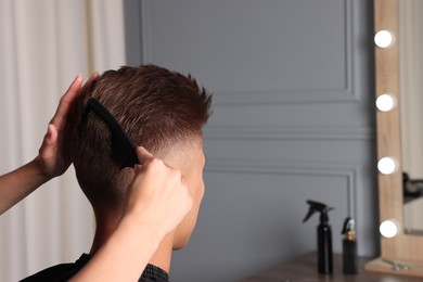 Hair cutting. Hairdresser combing man's hair in barbershop, closeup. Space for text