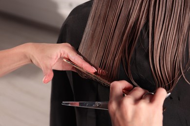 Photo of Hair cutting. Professional hairdresser working with client in salon, closeup