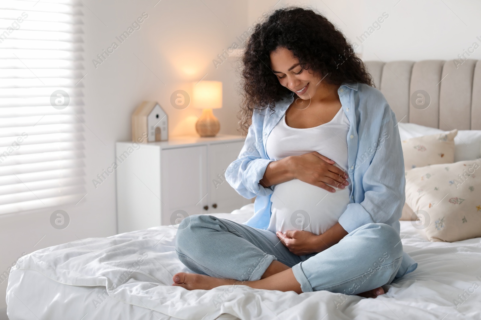 Photo of Portrait of beautiful pregnant woman on bed at home