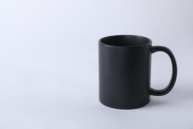 Photo of One blank black mug on white background. Mockup for design