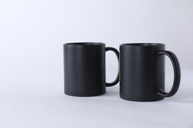 Two blank black mugs on white background. Mockup for design