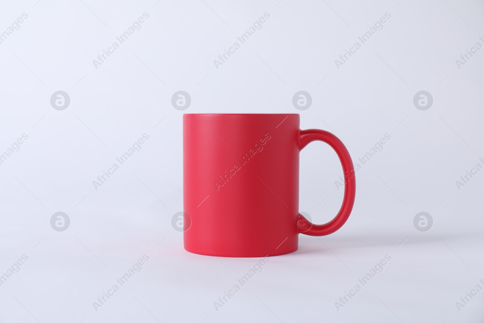 Photo of One blank red mug on white background. Mockup for design