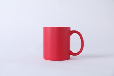 Photo of One blank red mug on white background. Mockup for design