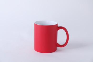 Photo of One blank red mug on white background. Mockup for design