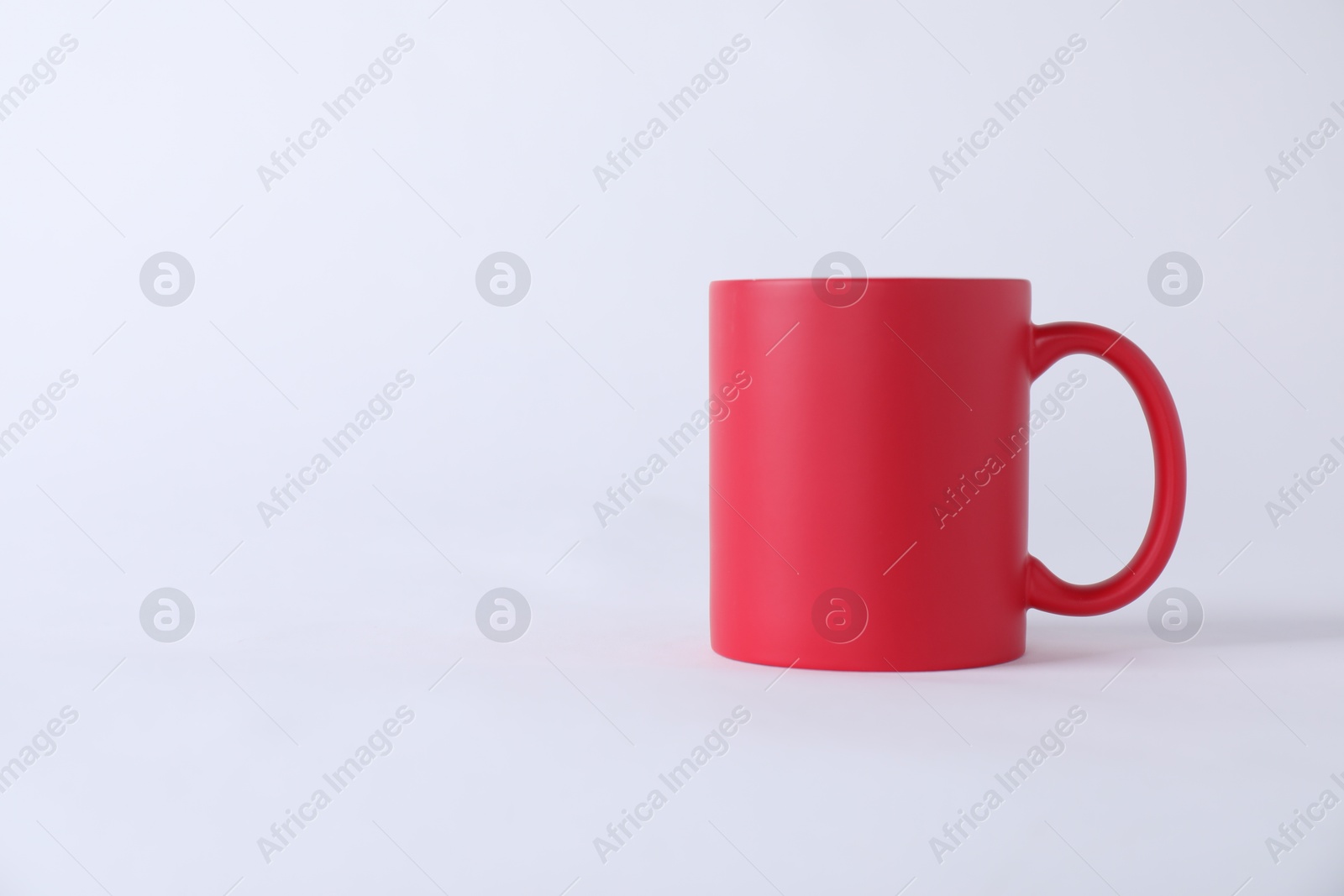 Photo of One blank red mug on white background. Mockup for design