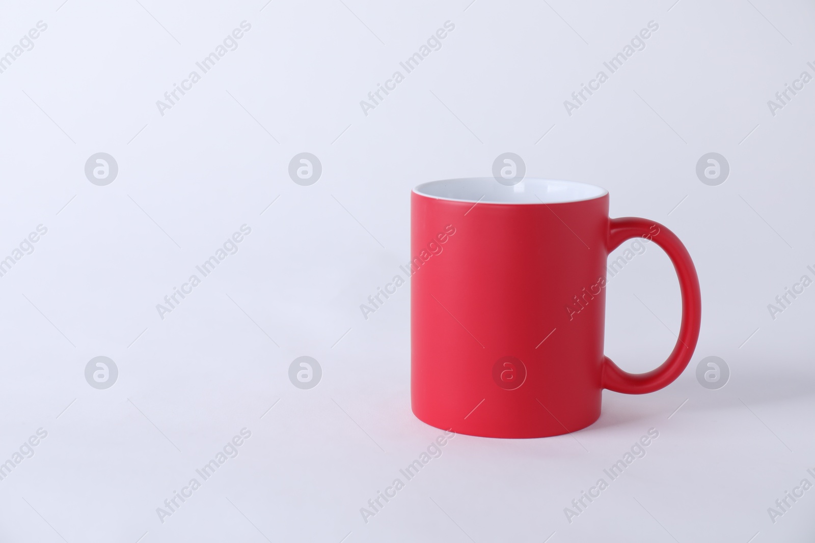 Photo of One blank red mug on white background. Mockup for design