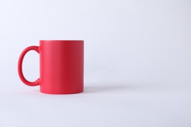 Photo of One blank red mug on white background. Mockup for design