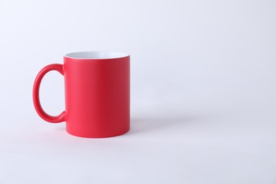 Photo of One blank red mug on white background. Mockup for design