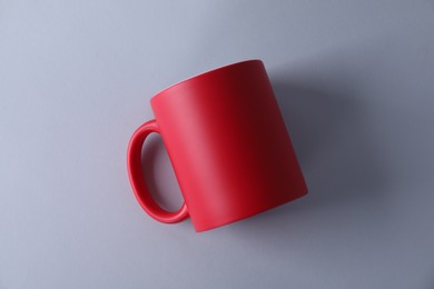 Photo of One blank red mug on light background, top view. Mockup for design