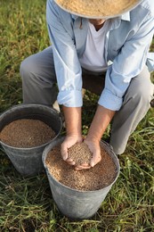 Photo of Senior man holding ripe wheat grains outdoors