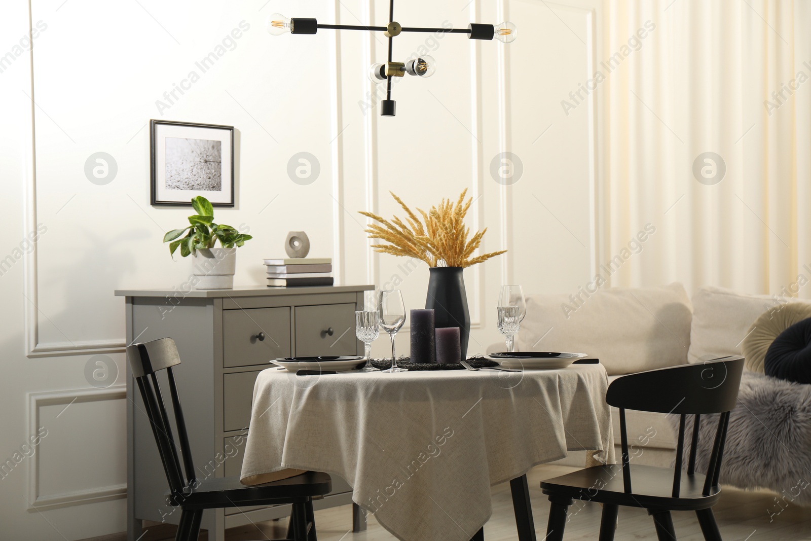 Photo of Stylish table setting with beautiful dishware and black chairs in dining room