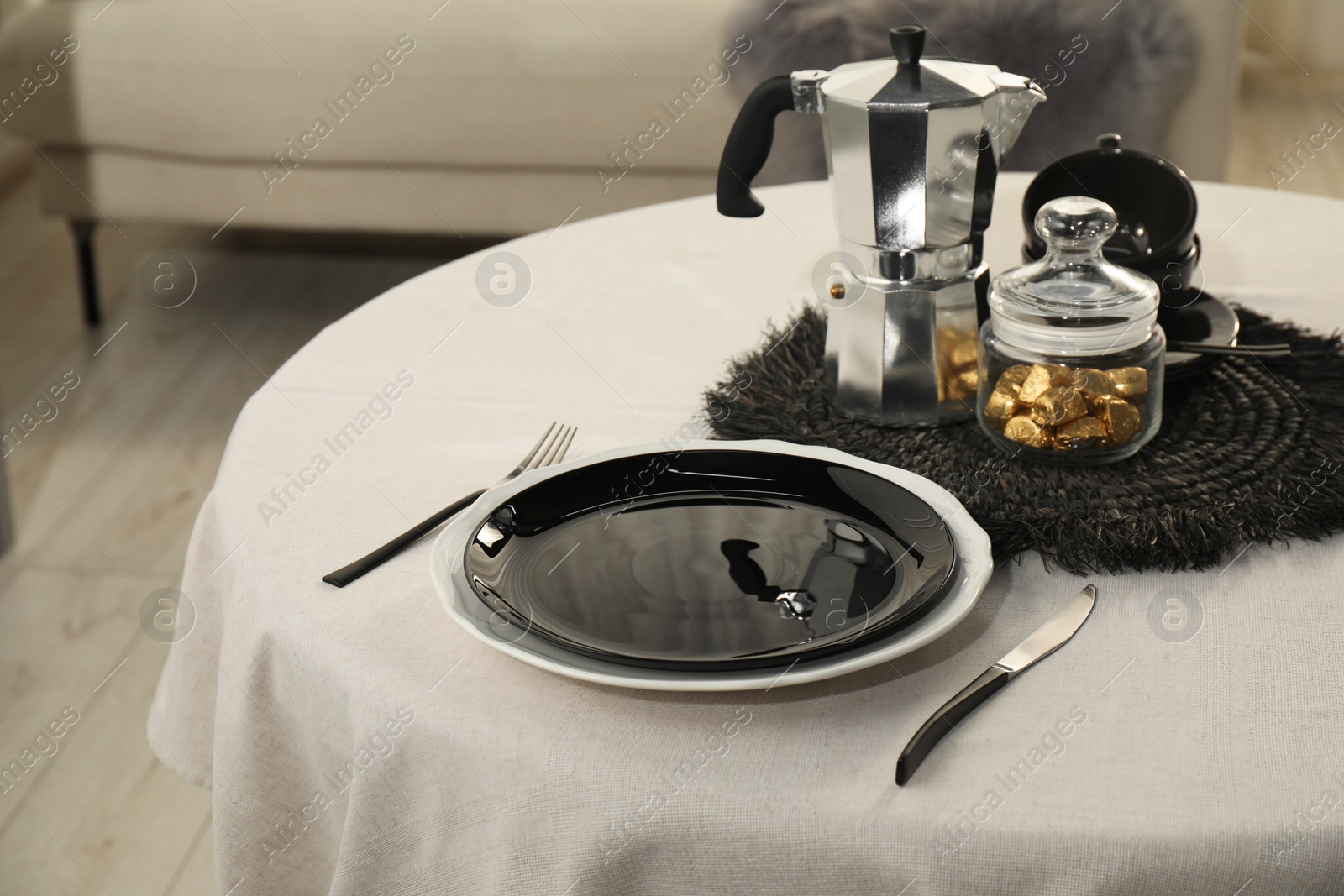 Photo of Stylish table setting with black dishware in dining room