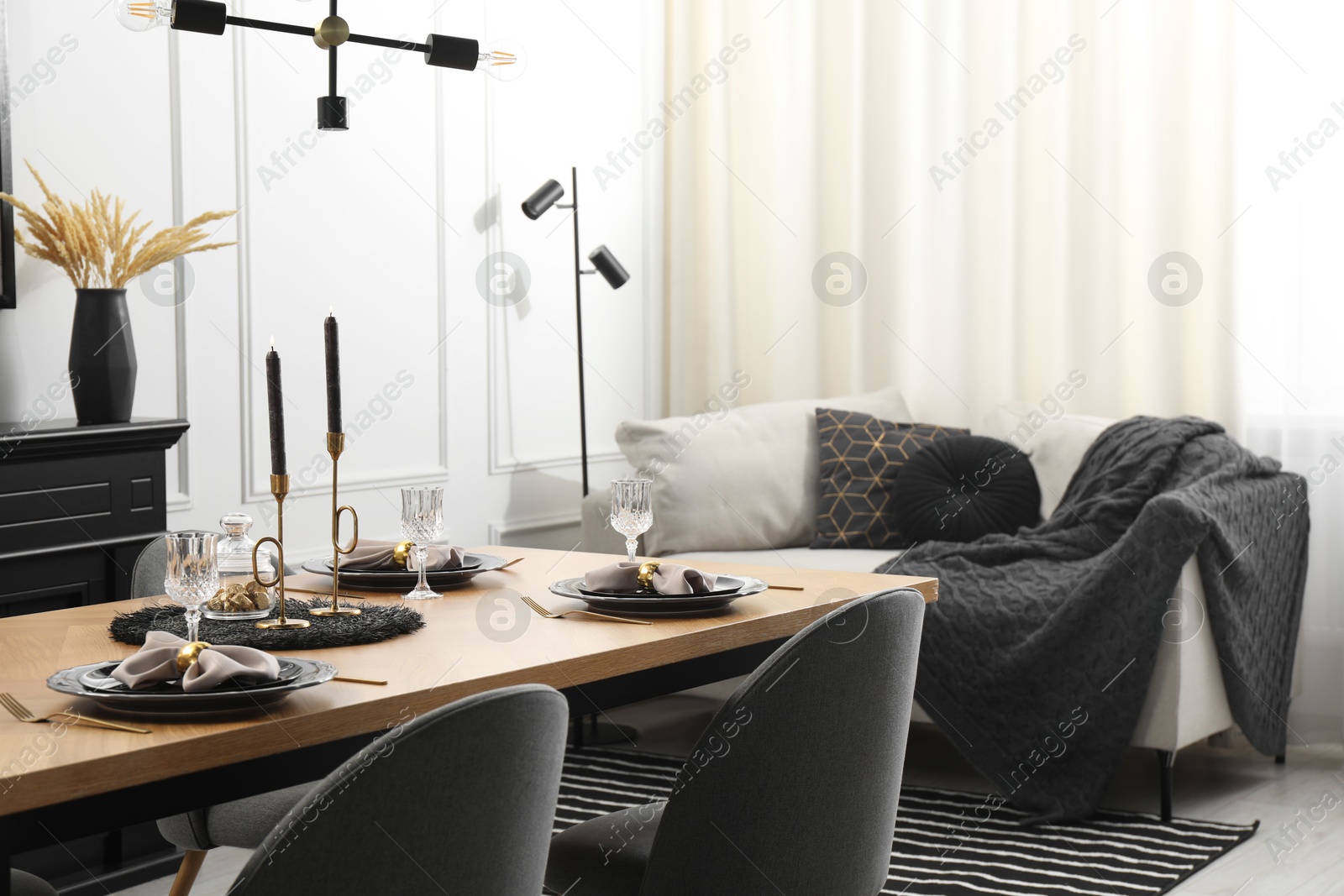 Photo of Stylish table setting with black dishware in dining room