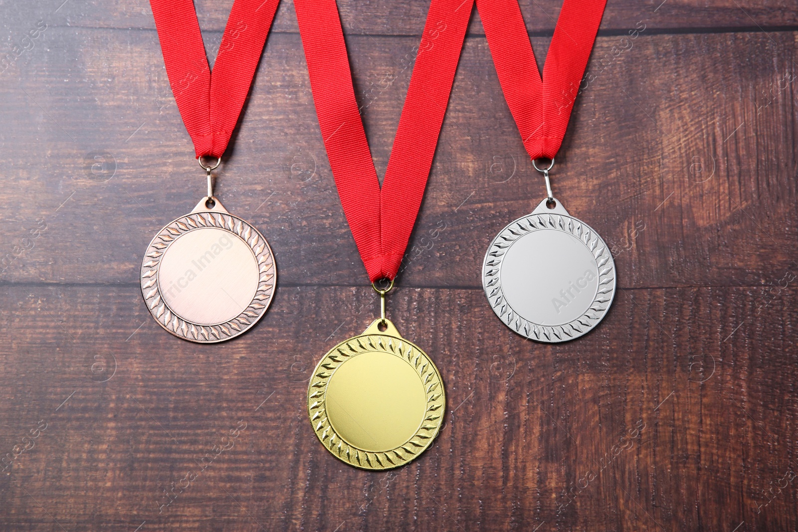 Photo of Golden, silver and bronze medals on wooden background, top view