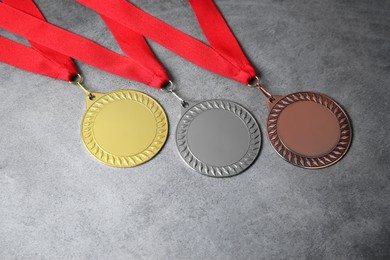 Photo of Golden, silver and bronze medals on grey background, above view