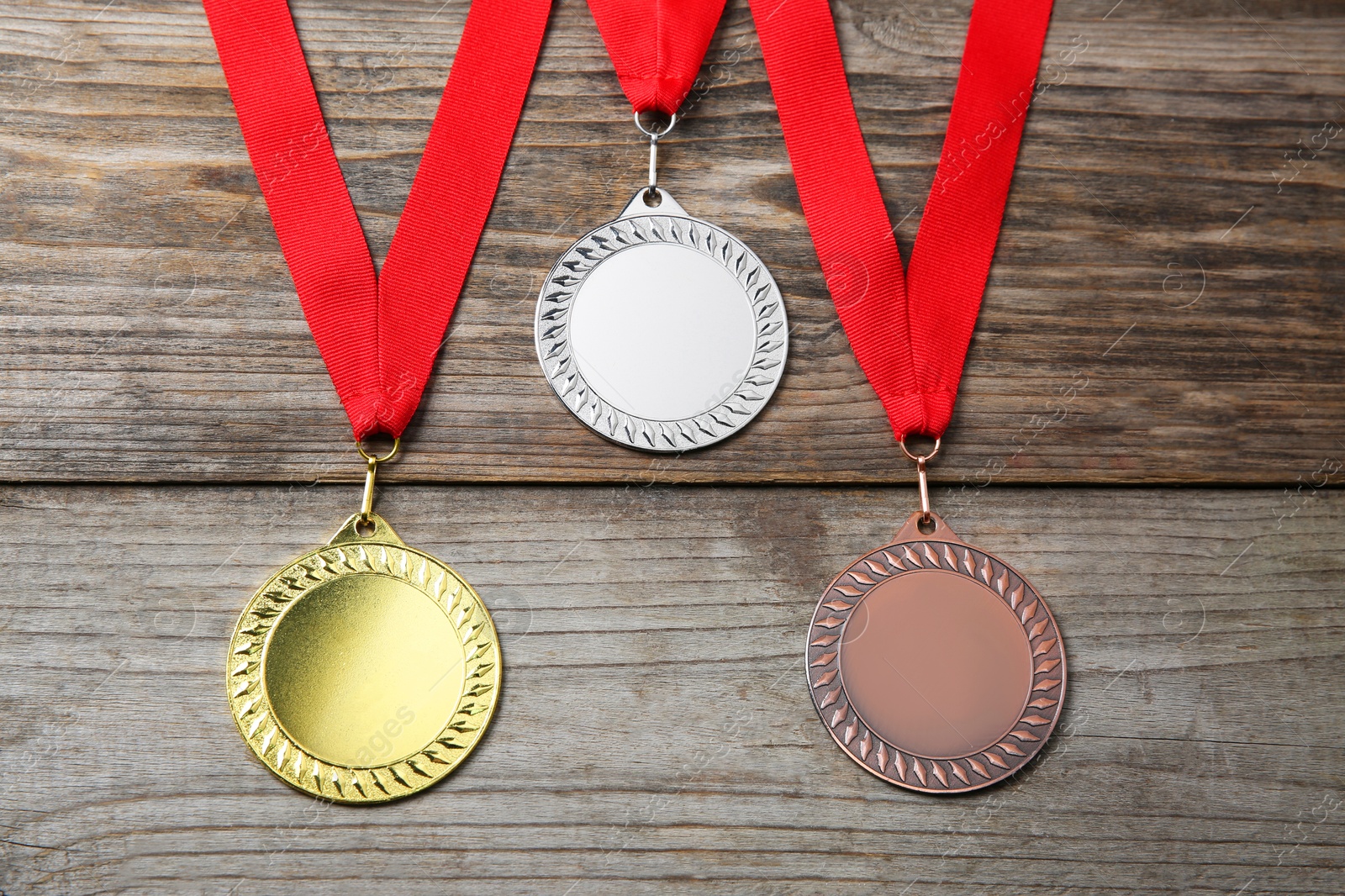 Photo of Golden, silver and bronze medals on wooden background, above view