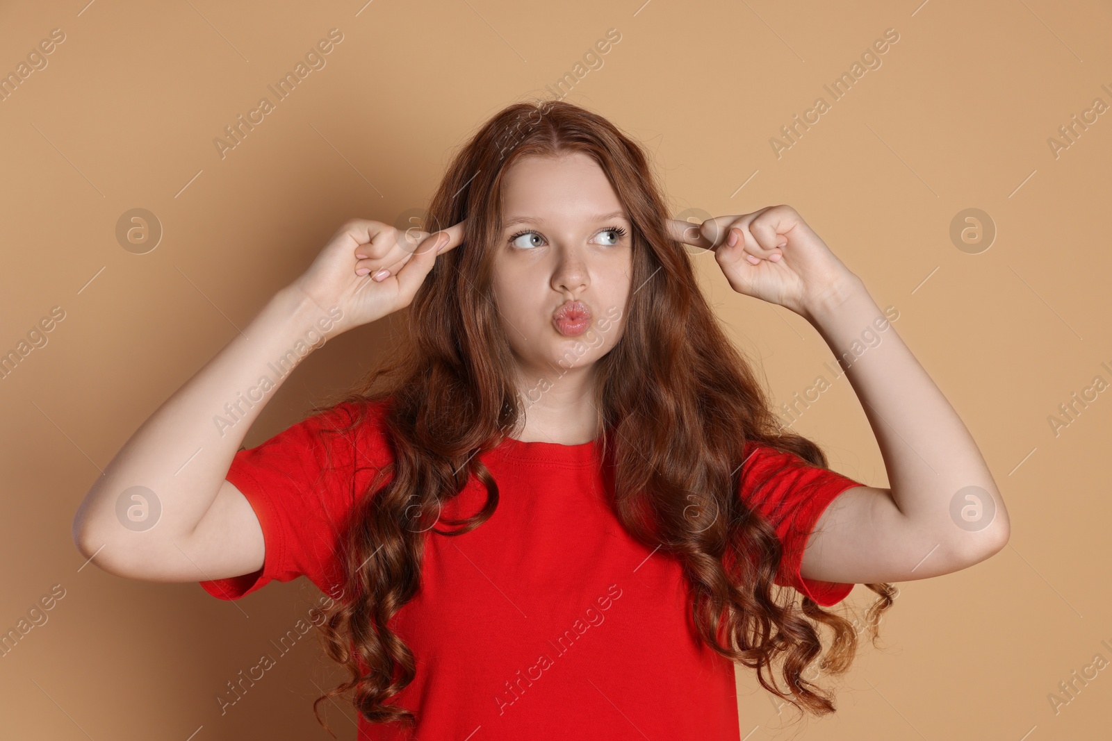 Photo of Cute teenage girl gesturing on beige background