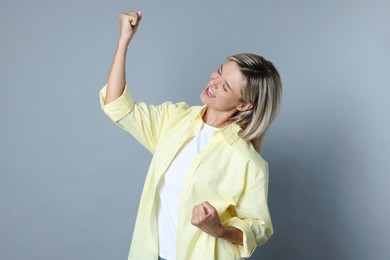 Photo of Portrait of happy winner on gray background