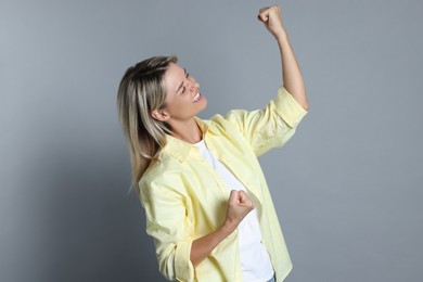 Portrait of happy winner on gray background