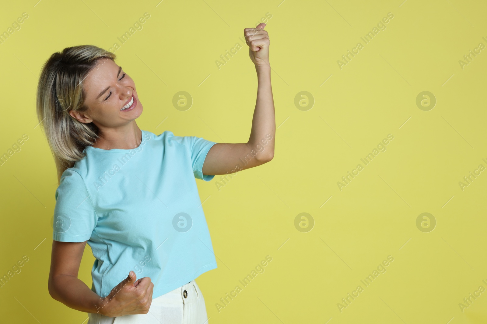 Photo of Happy winner on yellow background, space for text