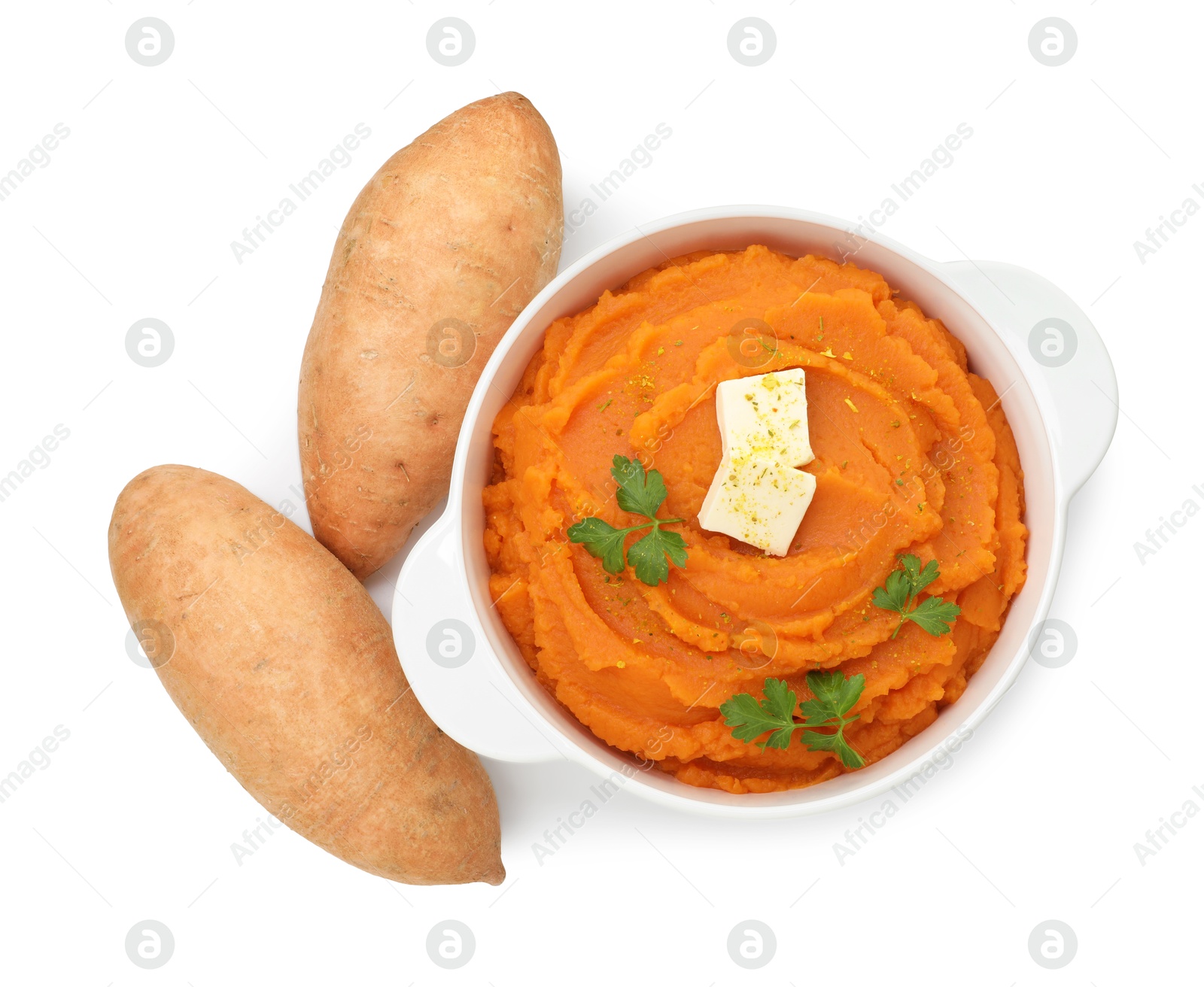 Photo of Tasty mashed sweet potato with butter in bowl and fresh vegetables isolated on white, top view